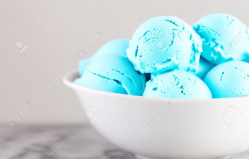 Mixed flavor ice cream scoops in a white bowl