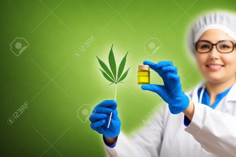 女醫生抱著大麻葉和油。替代醫學