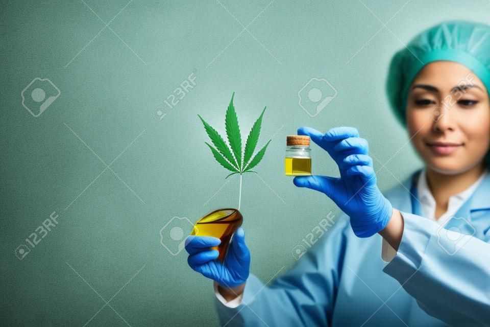 女醫生抱著大麻葉和油。替代醫學