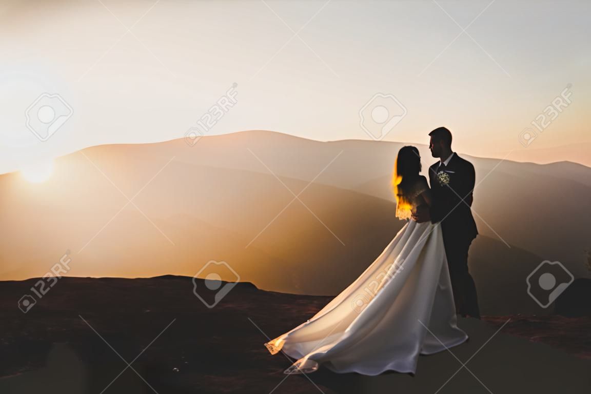 Gelukkig mooi huwelijk paar bruid en bruidegom op bruiloft dag buiten op de bergen rots. Gelukkig huwelijk paar buiten op de natuur, zachte zonnige lichten