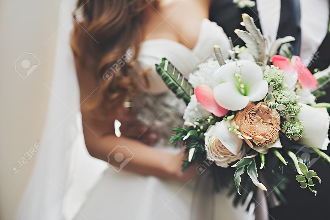 Luxe bruiloft boeket in bruiden en bruidegom handen