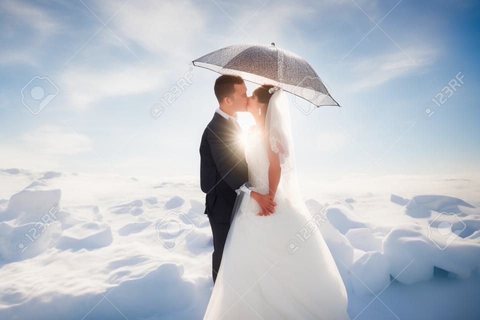 Perfect paar bruid, bruidegom poseren en kussen op hun trouwdag