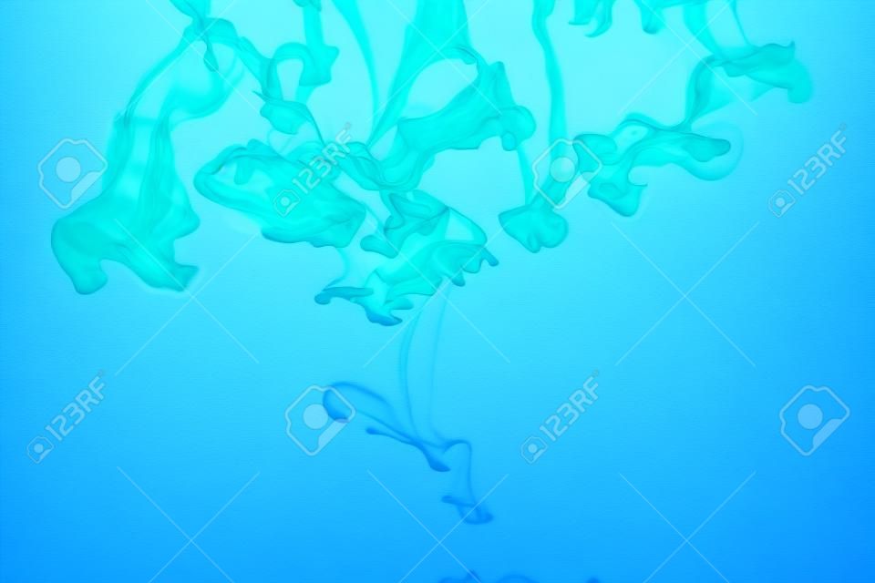 Inchiostro blu in acqua, colpo artistico, fondo astratto