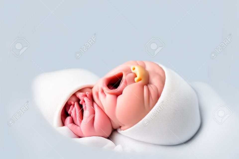 newborn baby yawning while lying in infant incubator