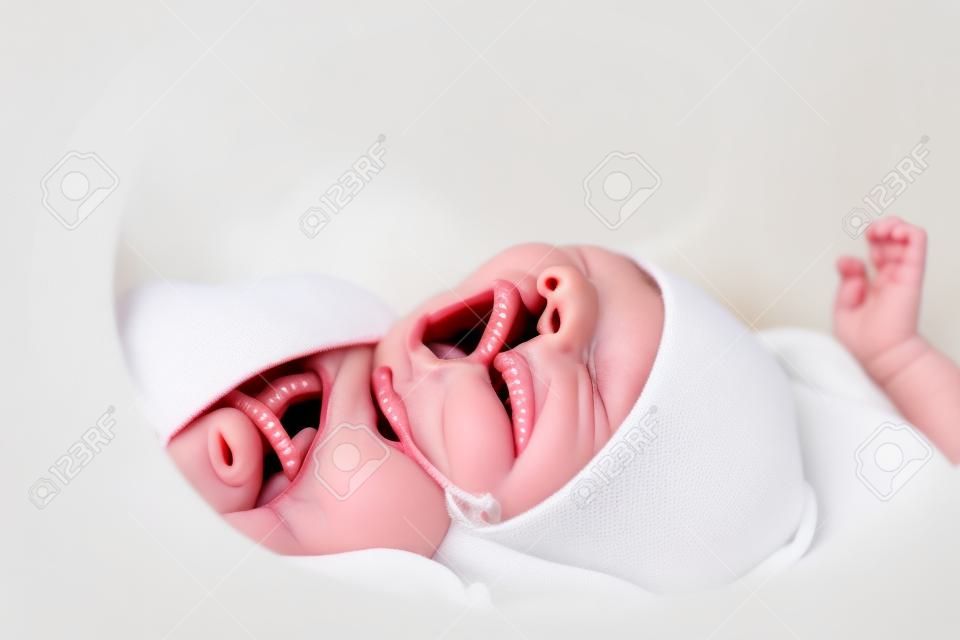 nouveau-né bâiller en position couchée dans l'incubateur infantile