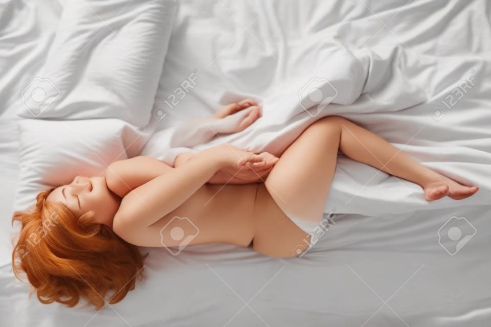Vista dall'alto di giovane donna dormire tranquillamente a letto