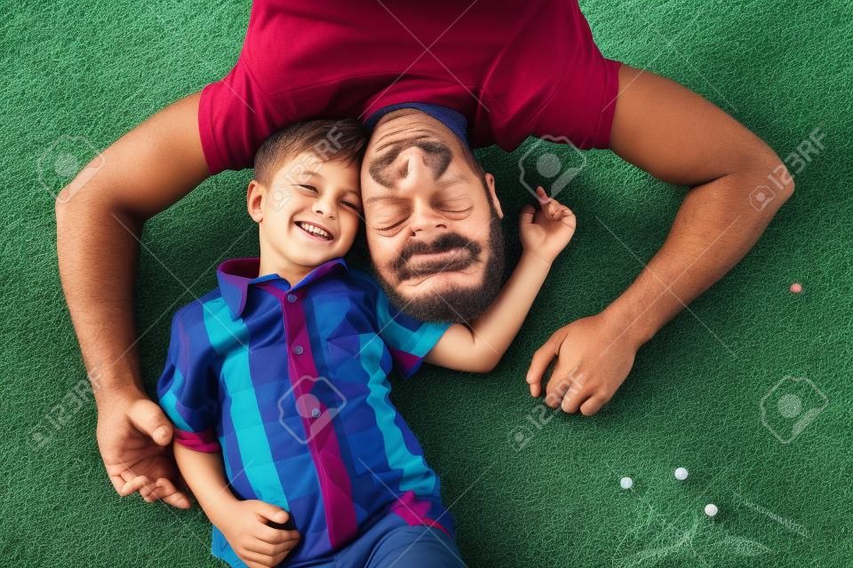 Vater und Sohn spielen auf dem Feld