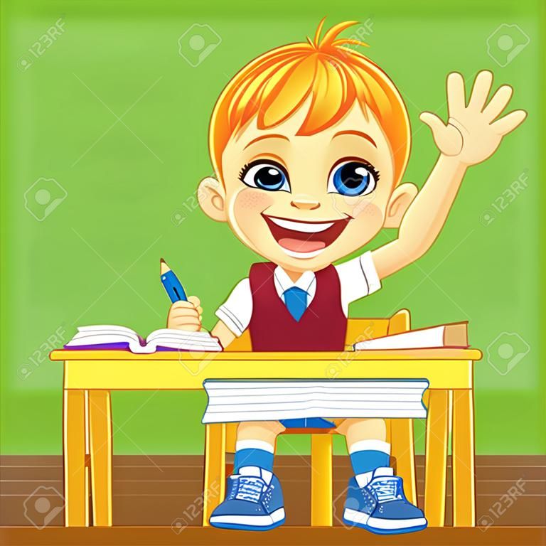 Smiling happy schoolboy in a school uniform sitting at a school desk