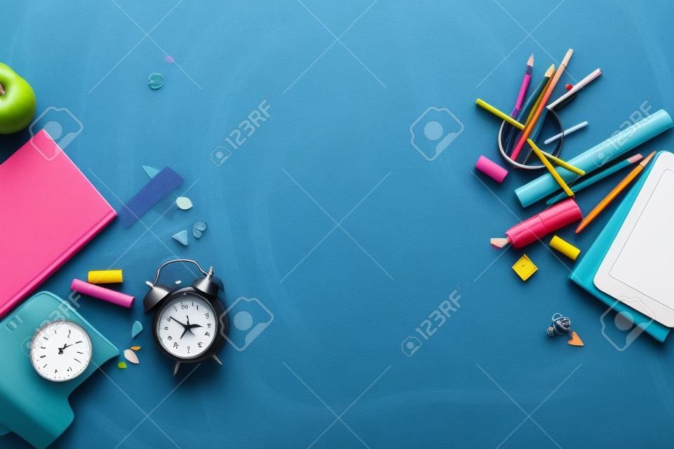Konzept zurück in die Schule Wecker Farbe Kreide Bleistift Apple Notebook Briefpapier auf schwarzen Tafel Hintergrund. Design-Exemplar liefert Draufsicht flaches Lay