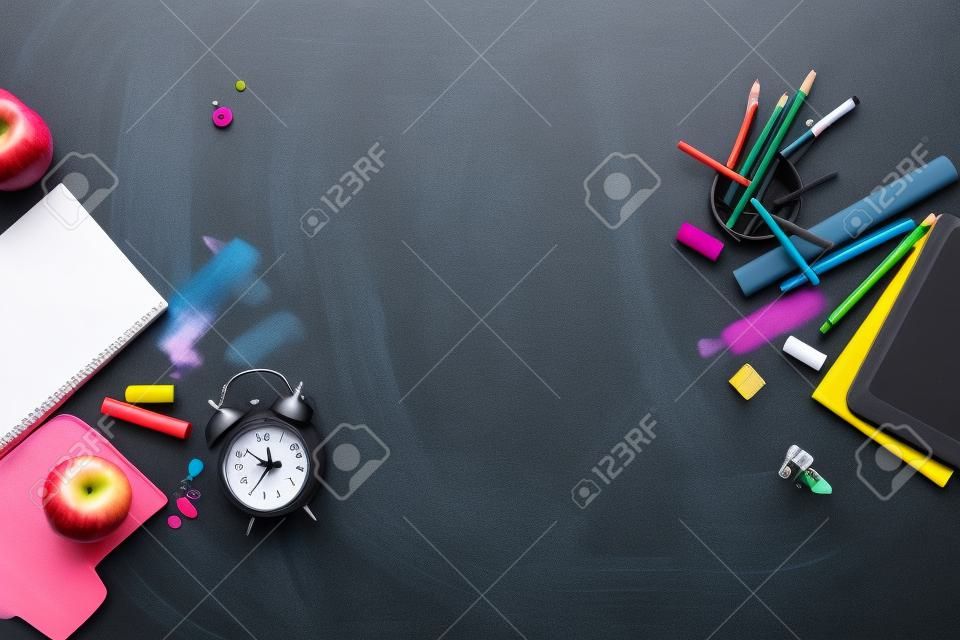 Concepto de nuevo al reloj de alarma de la escuela Color lápiz de tiza Papelería de Apple en el fondo de Black Blackboard. Diseño Copia Espacio Suministros Vista superior Plano Lay