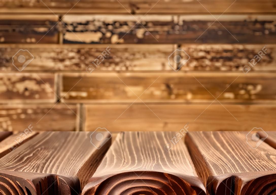 Empty wooden table with defocused wooden background.