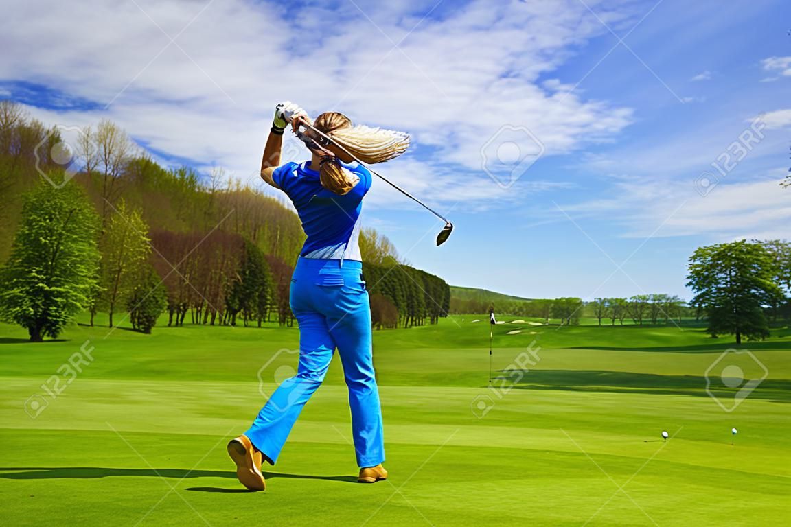 Женщина игрок в гольф удара железом от фарватера