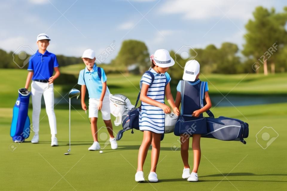 Niños caminando en espacio abierto con bolsas en la escuela de golf