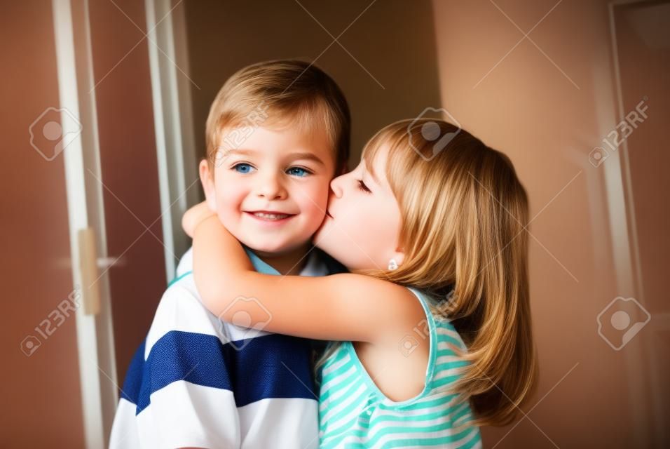 Adorable little girl kissing a boy