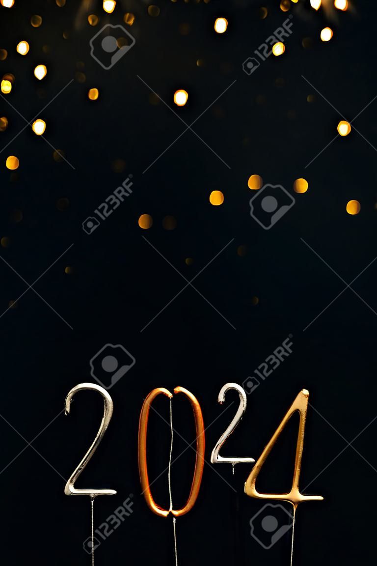 Numeri delle candele di sfondo natalizio di Capodanno 2024 in argento e oro su sfondo nero vista frontale