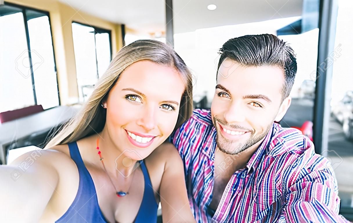 夫婦採取自畫像與智能手機。美麗的年輕夫婦selfie
