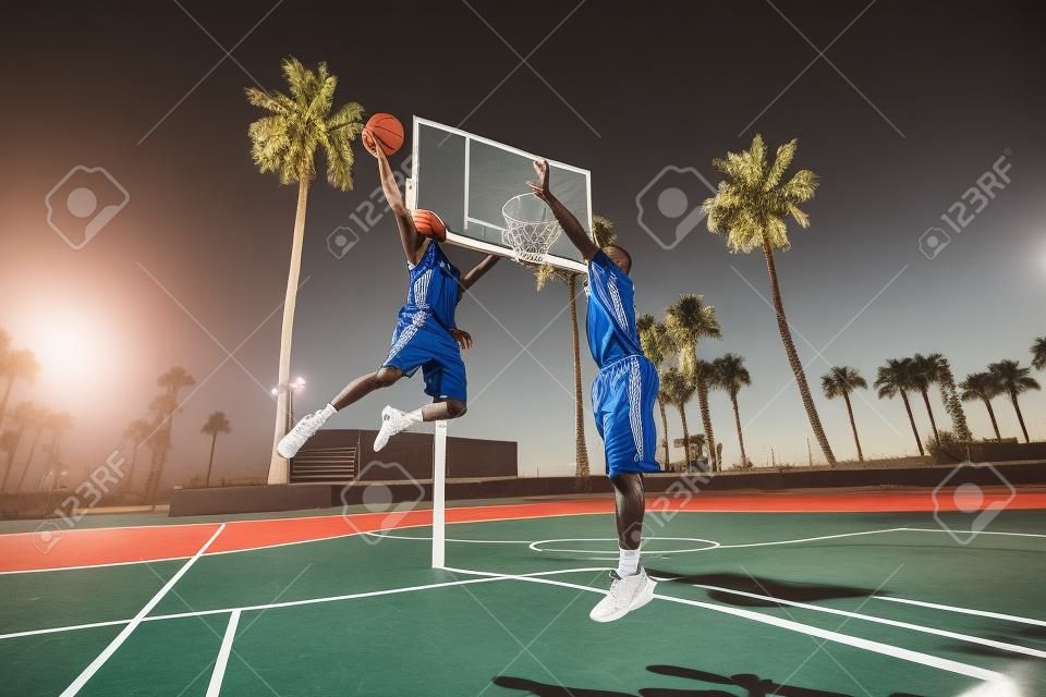Друзья играют в баскетбол - афро-американских игроков, имеющих товарищеский матч на открытом воздухе