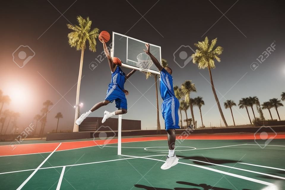 Amigos jogando basquete - jogadores afro-americanos que têm uma partida amigável ao ar livre