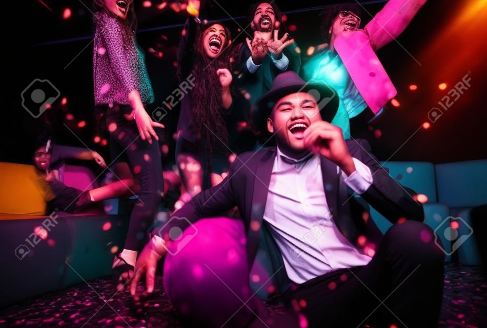 Groupe multi-ethnique d'amis célébrant dans une boîte de nuit - Clubbers ayant parti