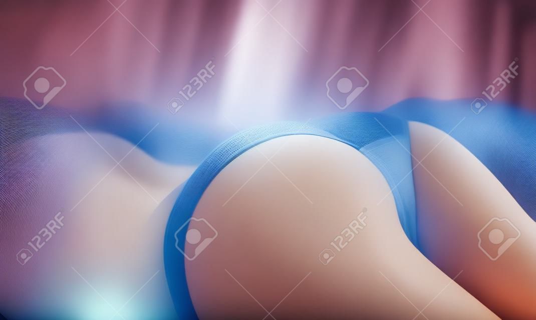 Femme fesse vue en position couchée dans son lit