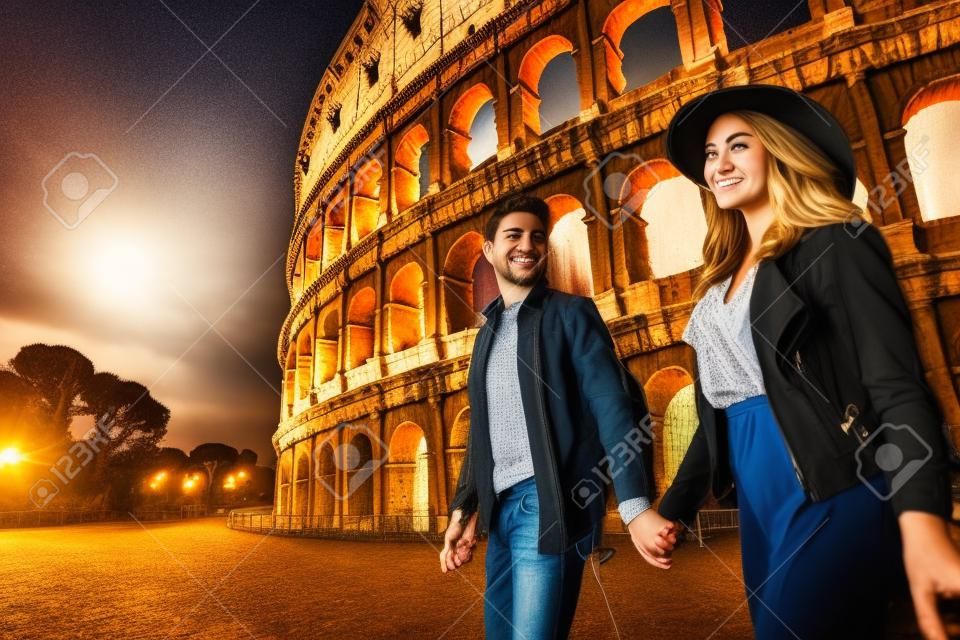 Joven pareja en el Coliseo, Roma - Felices turistas visitando monumentos famosos italianos