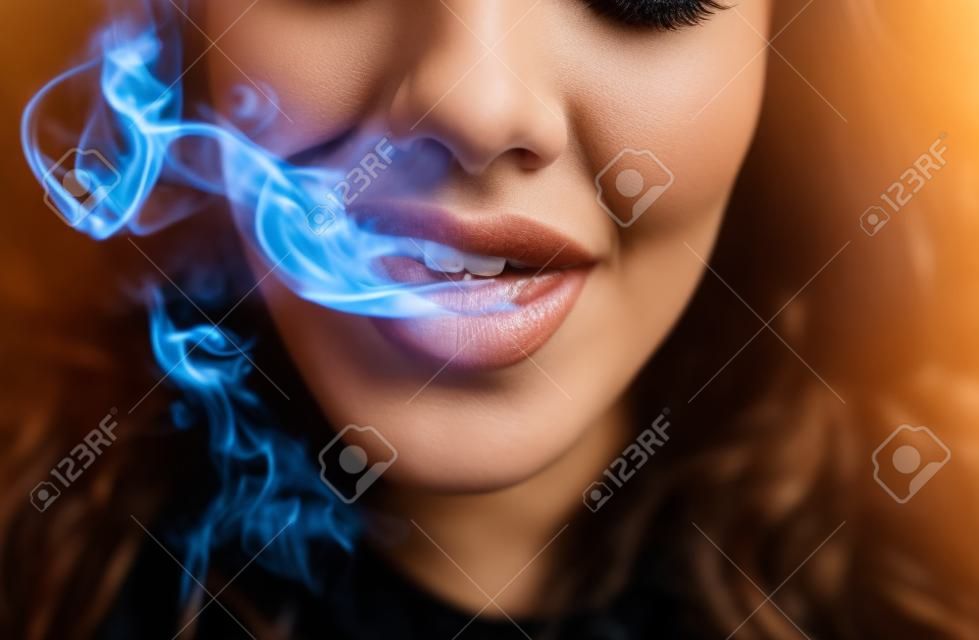 Mulher que fuma, fecha acima na fumaça e na boca