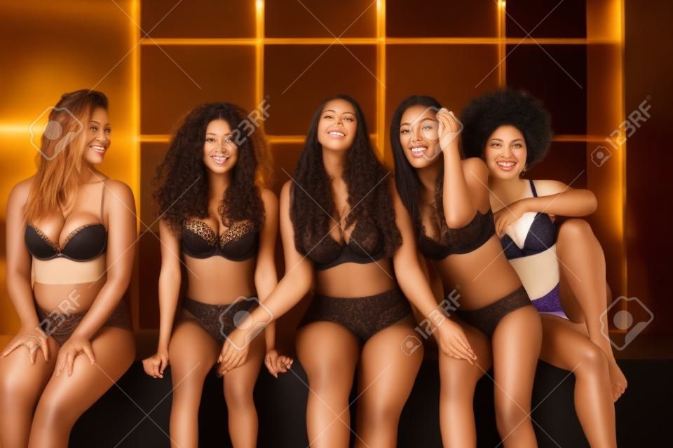Multiethnische Gruppe schöner Frauen, die in Unterwäsche in einem Schönheitsstudio posieren