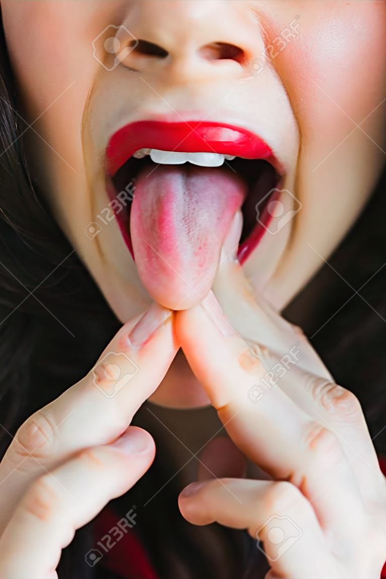 Image of a woman sticking her tongue out between the fingers