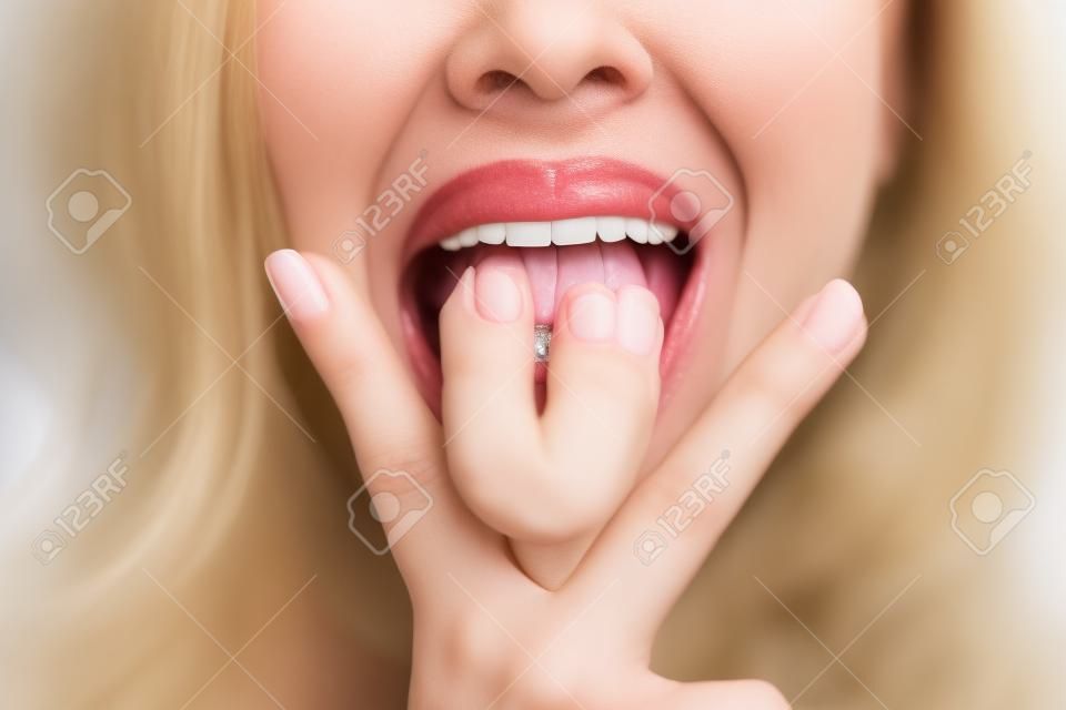 Obraz kobiety wystającej z języka między palcami