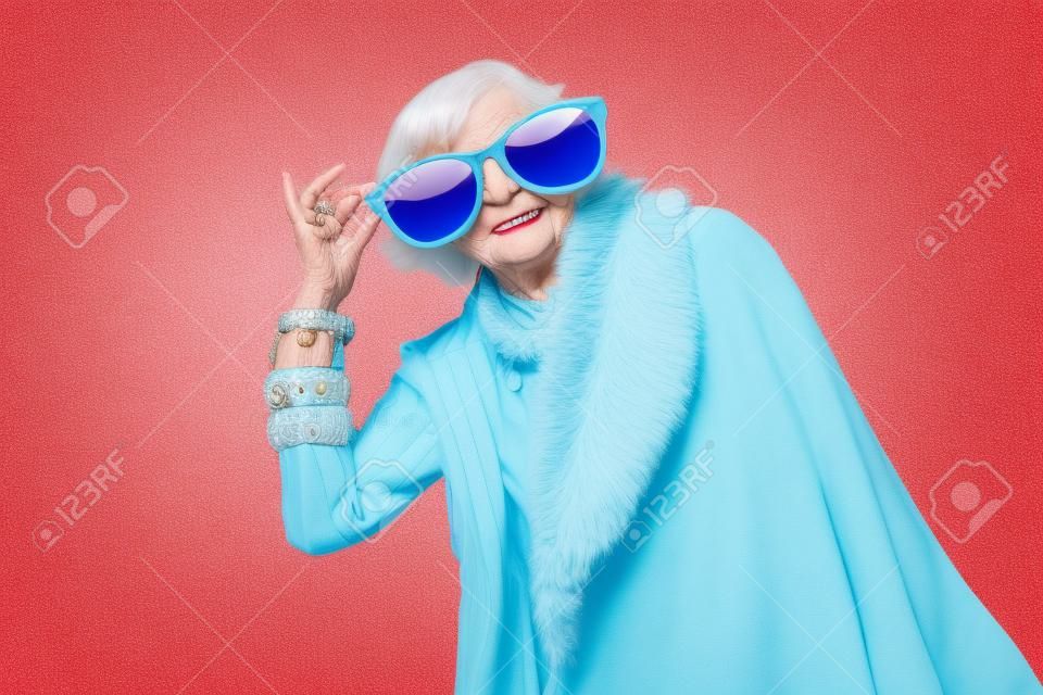 Szczęśliwa i zabawna fajna starsza pani z modnym portretem na kolorowym tle - młoda babcia z ekstrawaganckim stylem, koncepcjami stylu życia, stażu pracy i osób starszych