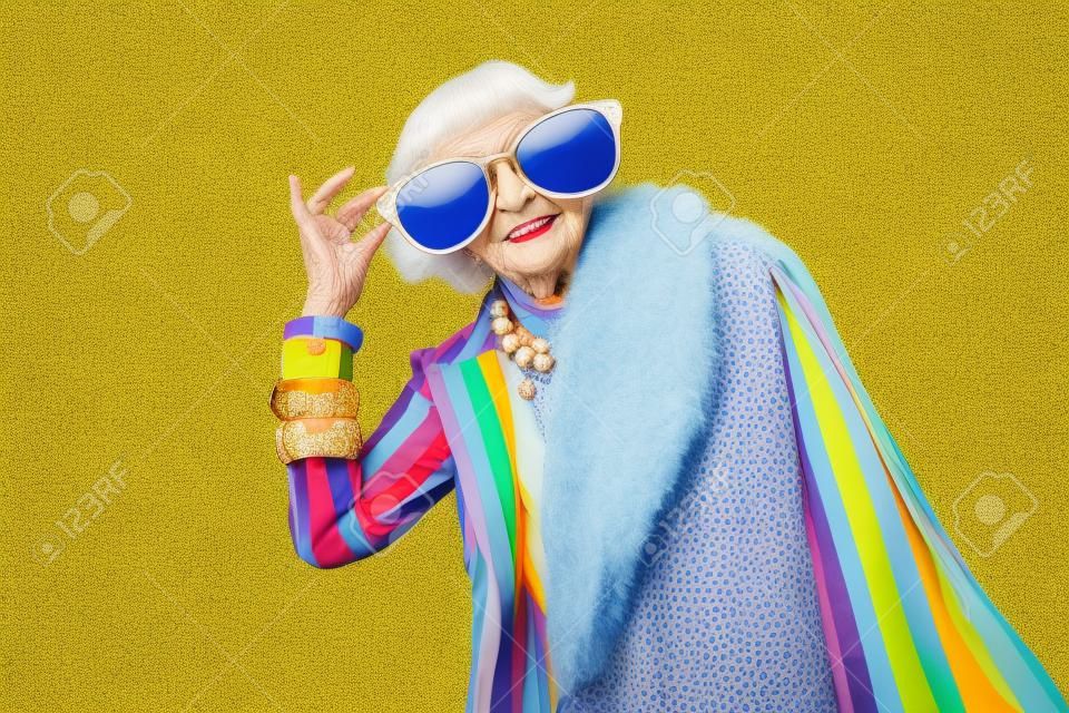 Szczęśliwa i zabawna fajna starsza pani z modnym portretem na kolorowym tle - młoda babcia z ekstrawaganckim stylem, koncepcjami stylu życia, stażu pracy i osób starszych