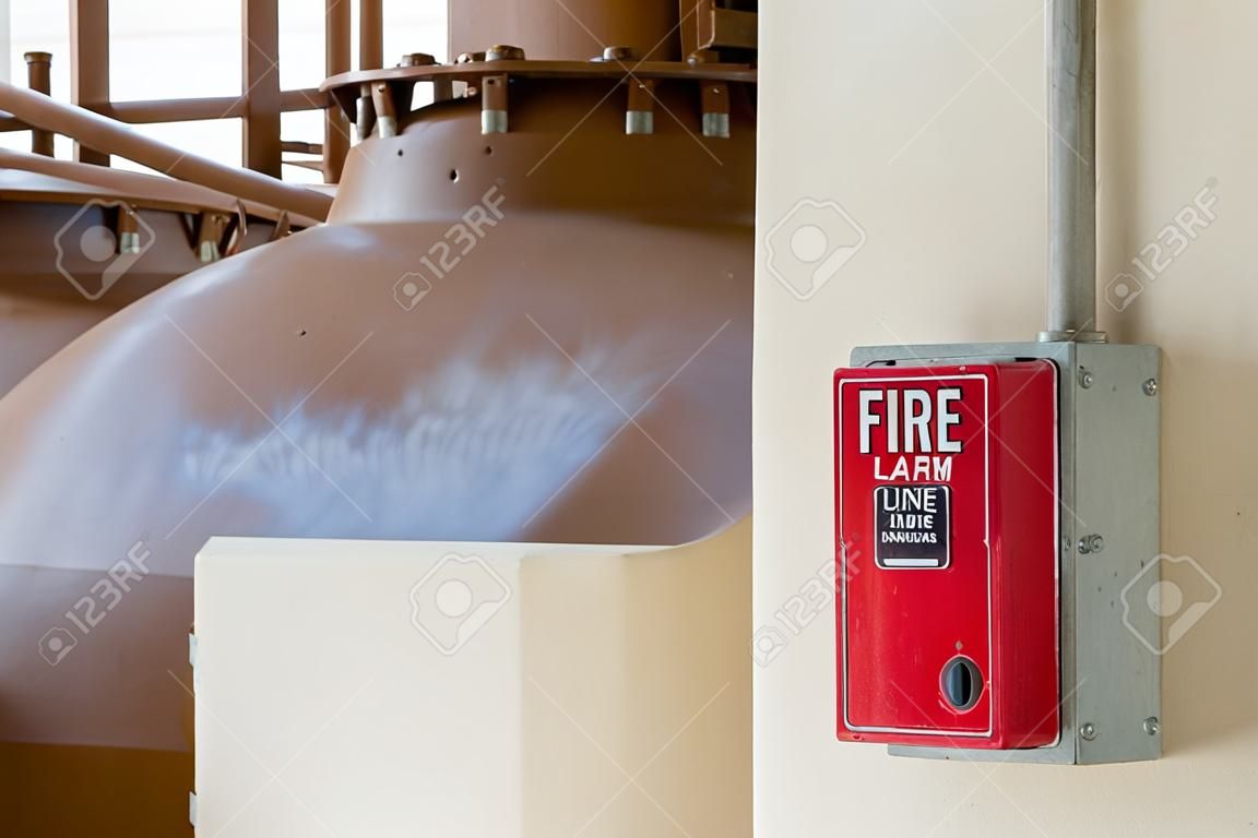 Equipo de alarma de incendio o punto de llamada manual de incendio en caja roja en la pared de cemento para advertencia, alerta y señalización del edificio de alarma de evacuación por el pasillo de salida antes de que el Equipo de Rescate ataque la lucha contra incendios.