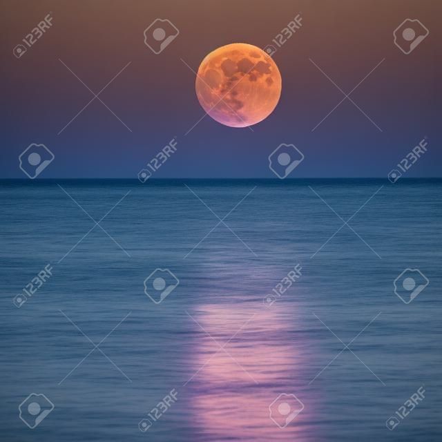 voller Super-Mond unter dem das Licht sehen auf dem Wasser bekommen