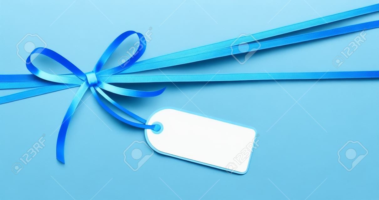 EPS 10 vector illustration of blue colored ribbon bow with hang tag and free text space isolated on white background