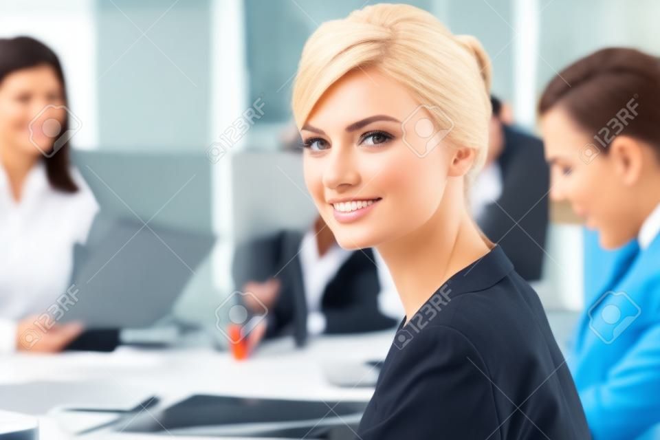 femme d'affaires avec son personnel, le groupe de personnes en arrière-plan au bureau moderne et lumineux intérieur