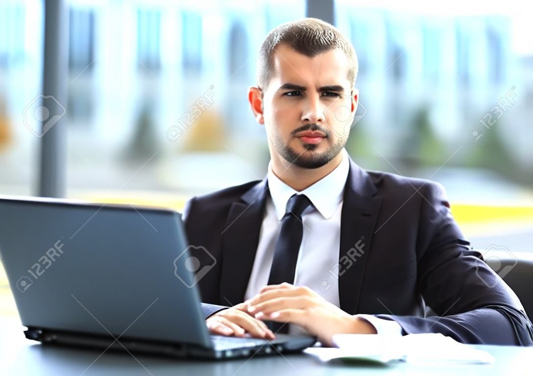 Przystojny biznesmen pracy z laptopem w biurze