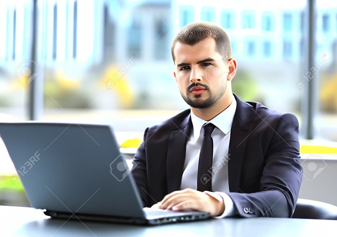 Handsome businessman working with laptop in office