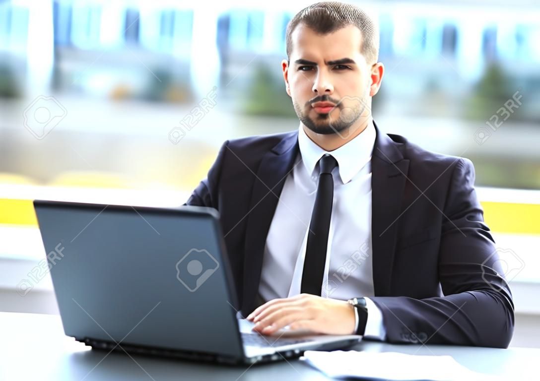 Handsome businessman working with laptop in office