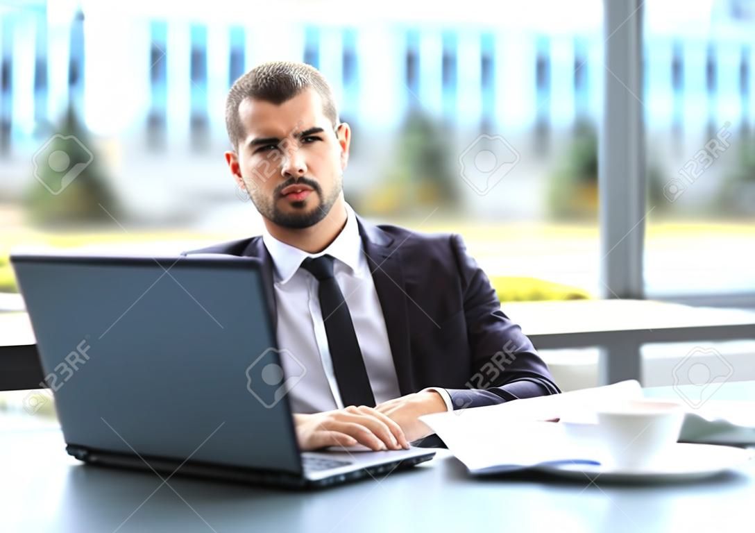 Apuesto hombre de negocios que trabajan con ordenador portátil en la oficina