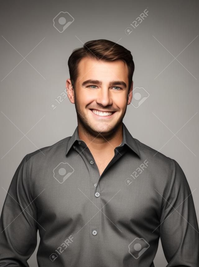 Handsome caucasian man smiling portrait on grey isolated background with brown shirt