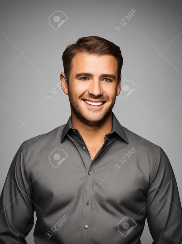 Handsome caucasian man smiling portrait on grey isolated background with brown shirt