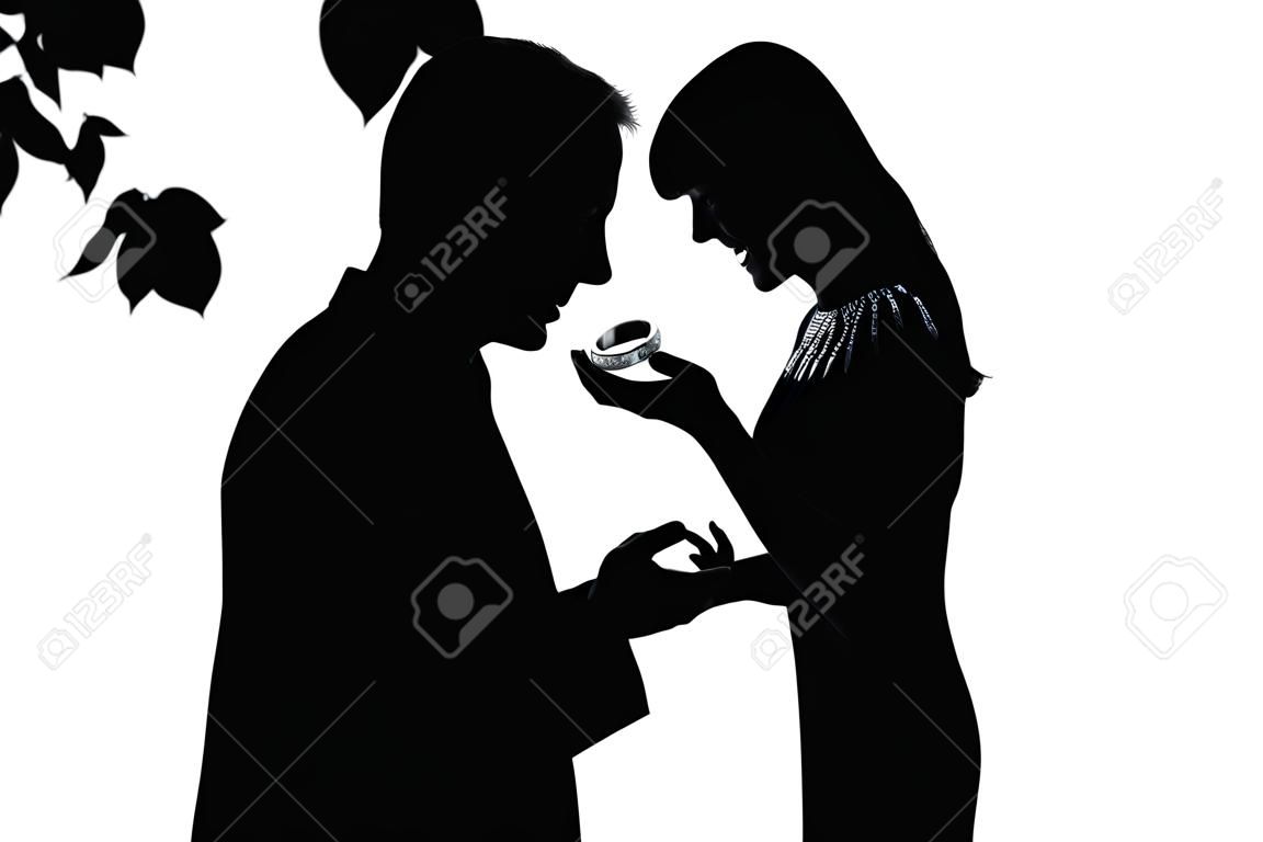 one caucasian couple man offering engagement ring and woman surprised in studio silhouette isolated on white background