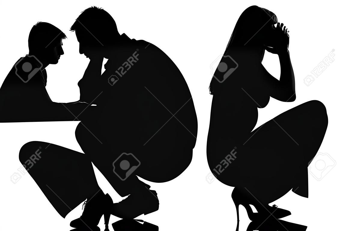 un hombre triste caucásico y mujer agachada de espaldas en el estudio de la silueta sobre fondo blanco
