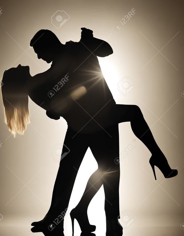 ein paar Liebhaber kaukasisch Mann und Frau tanzen Tango im Studio Silhouette auf weißem Hintergrund isoliert
