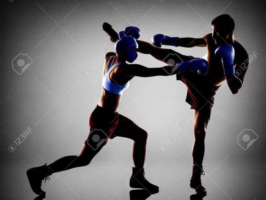 一名女子拳击手拳击一个男子跆拳道在孤立的白色背景上的剪影