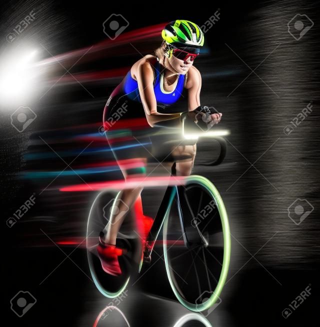 one caucasian woman triathlon triathlete cyclist cycling studio shot isolated on black background with light painting effect