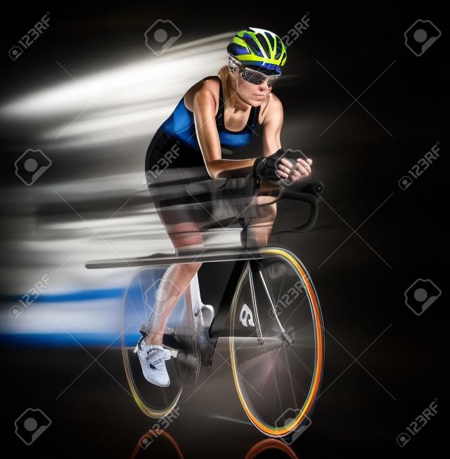 one caucasian woman triathlon triathlete cyclist cycling studio shot isolated on black background with light painting effect