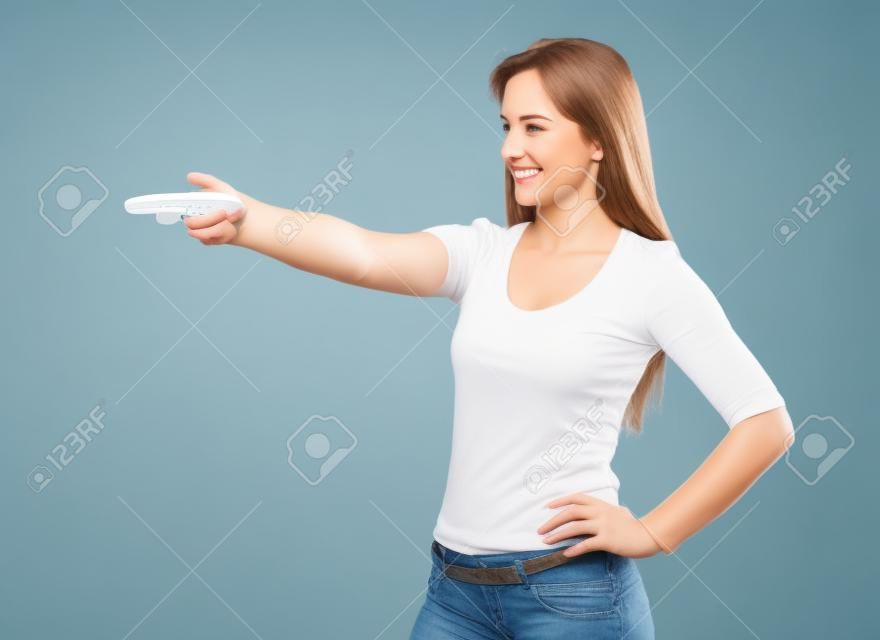Portrait d'une jolie dame pointant la télécommande