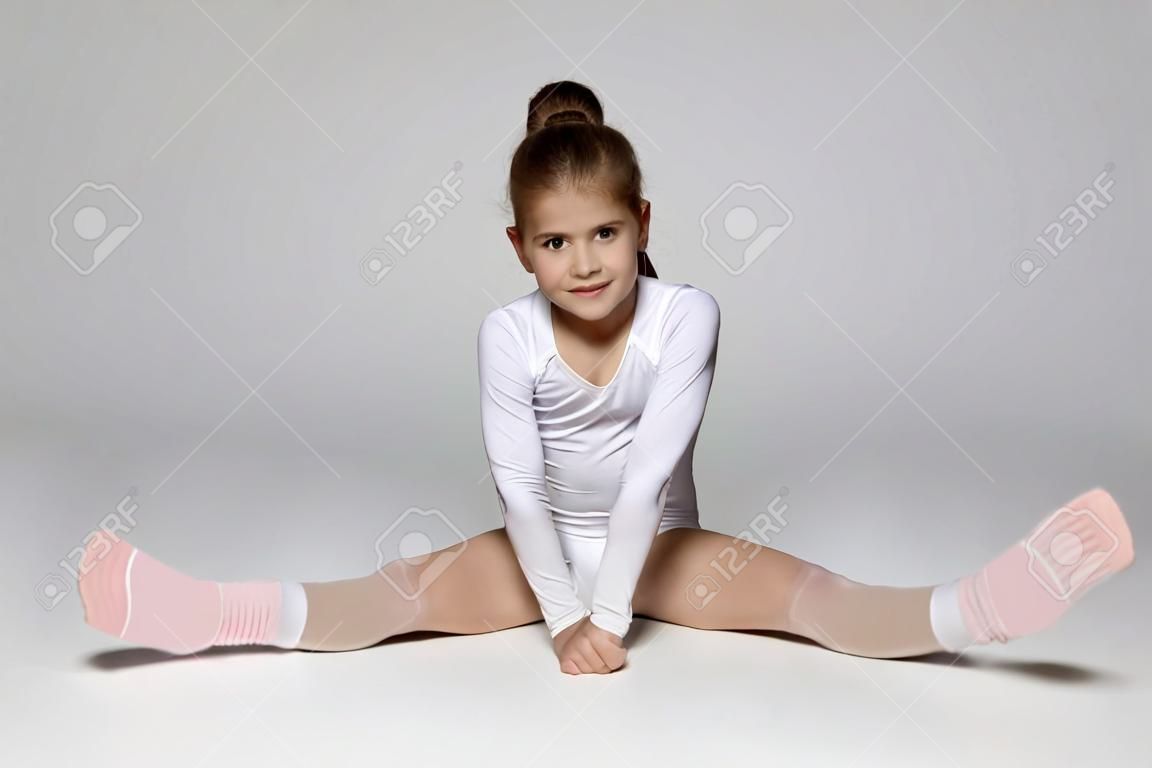Kinder sport wenig Sport Mädchen auf dem Boden der Ausübung Dehnung der Muskeln