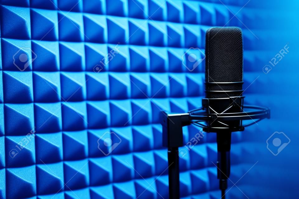 Studio-Kondensatormikrofon auf blauem Akustikschaumplattenhintergrund mit Kopienraum auf der linken Seite